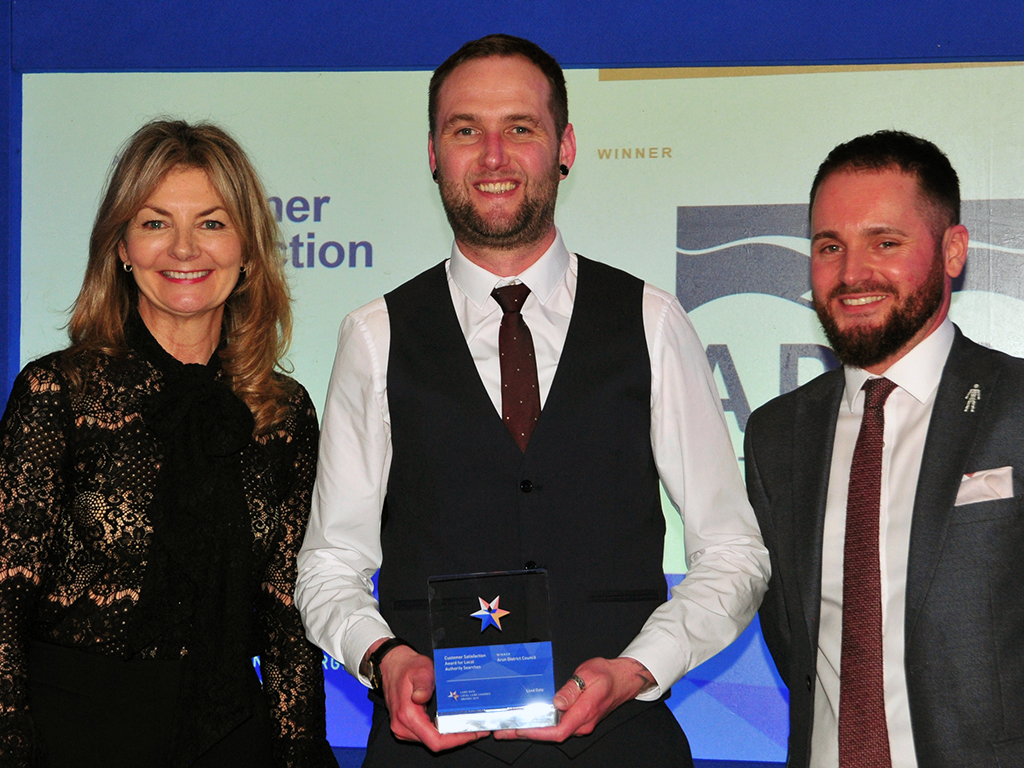 Andrew Simpson of the Coal Authority, right, with the awards host, comedian and writer Jo Caulfield, and Daniel Carmen from winners Arun District Council