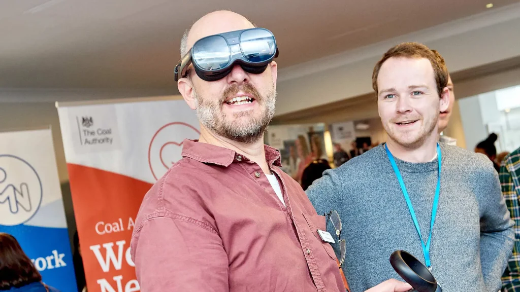 Colleagues demoing a VR headset.